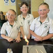 Three students using science equipment